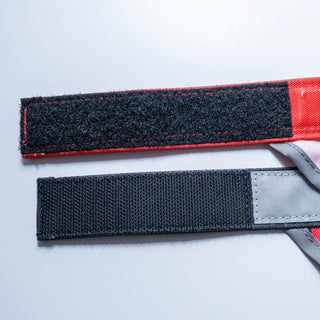 Two straps with red and gray ends on a light gray background